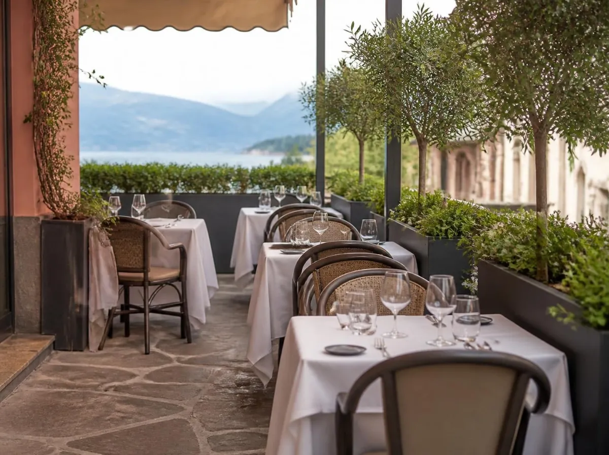 Dehors di un ristorante con tavoli apparecchiati e fioriere lungo il bordo
